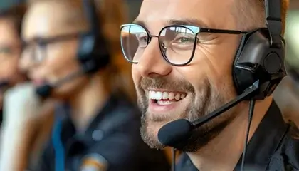 Man wearing headset smiling, assisting customer