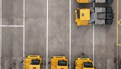 Three yellow trucks parked in a lot