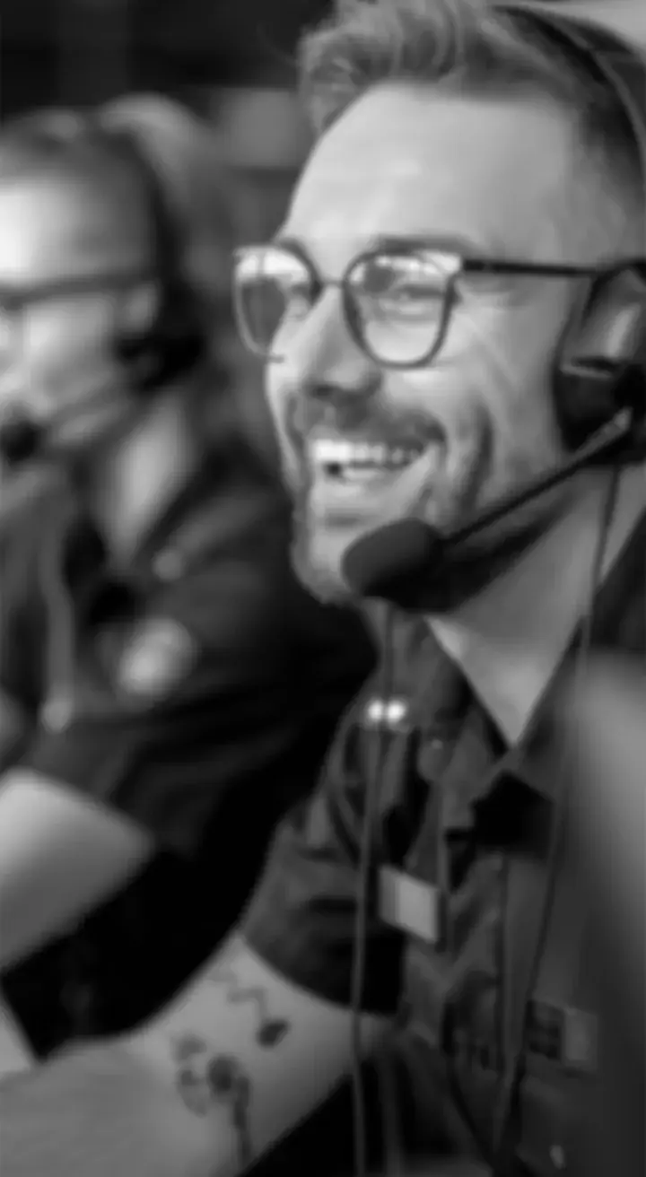 Man with glasses wearing headset, smiling